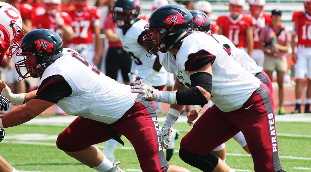 Chad Wilburg and Whitworth defensive line rush the Central quarterback in a Whitworth athletics file photo.