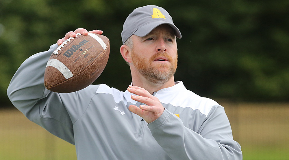 B.J. Hammer throwing a football while wearing an Allegheny cap